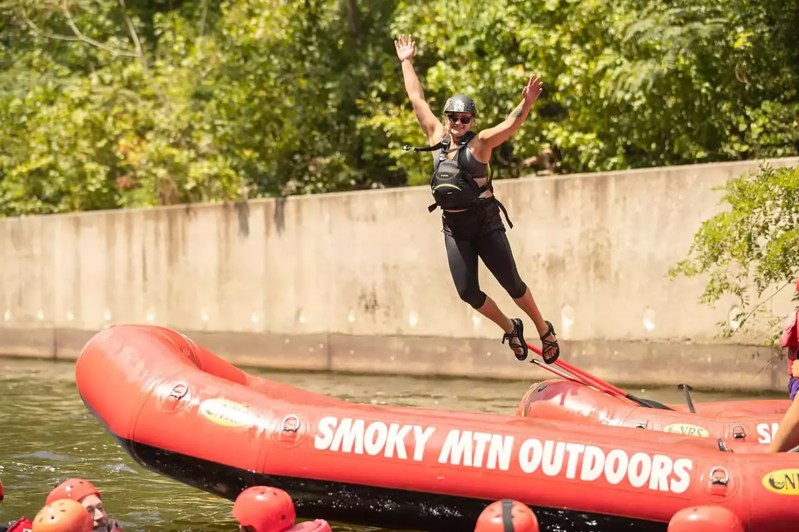 rafting guide jumping into river from raft