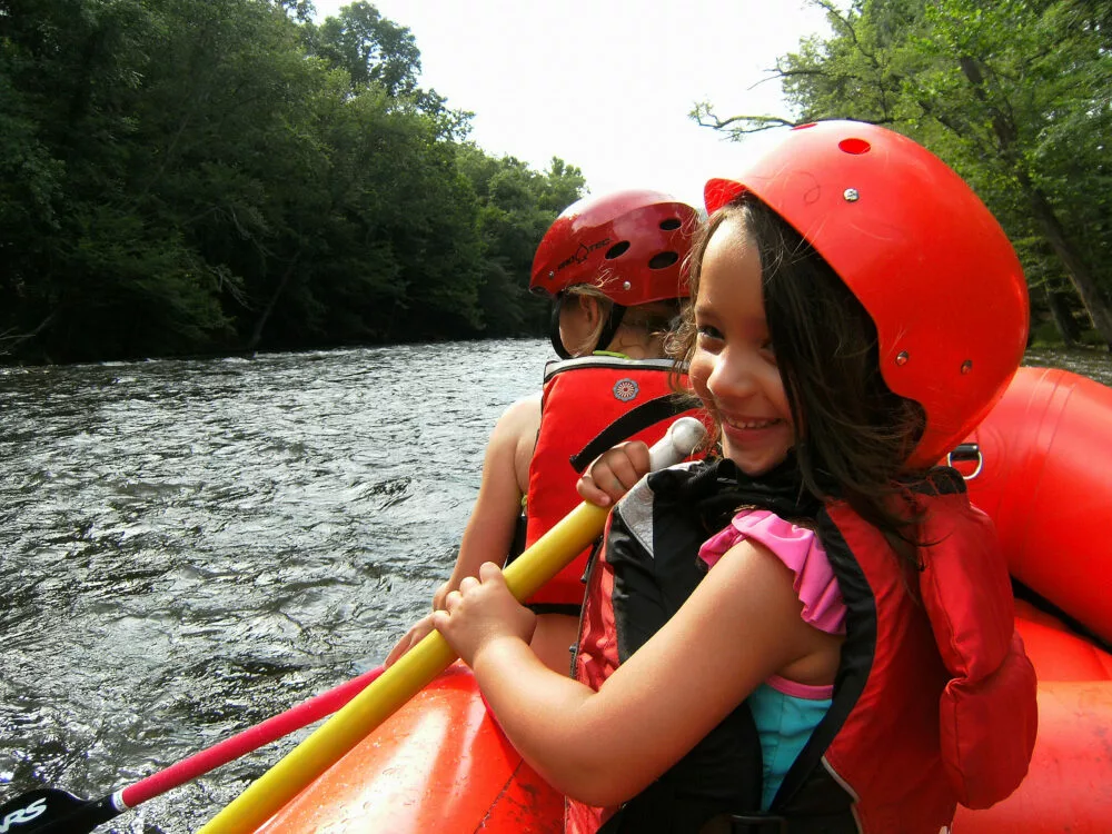 young girl smiling while whitewater rafting