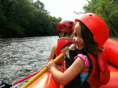 Little girl smiling while white water rafting