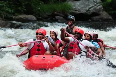 Laughing family enjoying a whitewater rafting trip with Smoky Mountain Outdoors