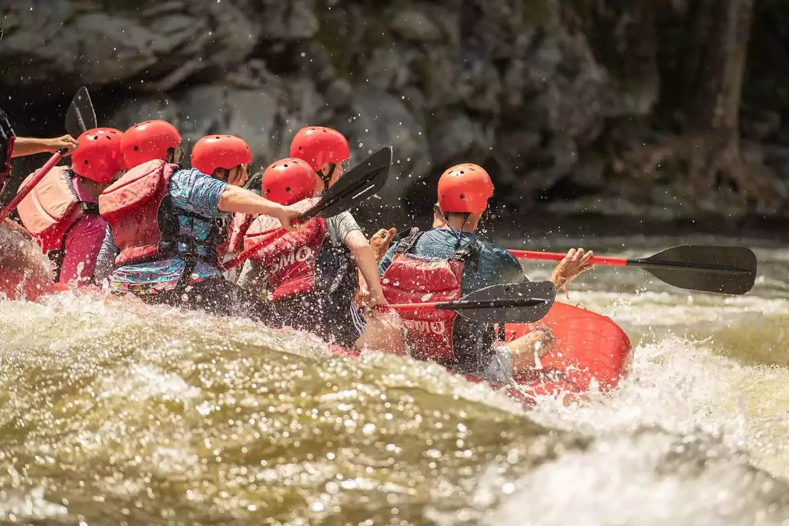 view of white water raft from behind through rapids