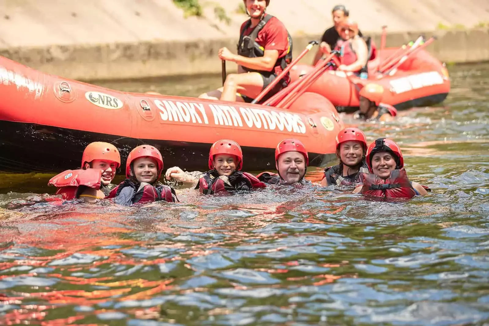 rafters floating in river next to raft