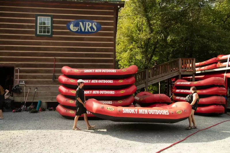 two guides carrying red raft at Smoky Mountain river rafting outpost
