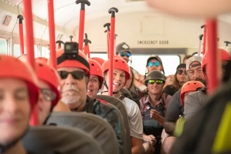 rafters on bus with helmets and paddles