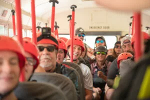 rafters on bus with helmets and paddles