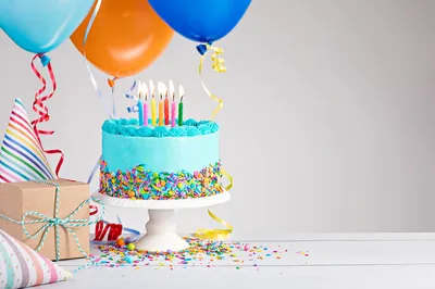 birthday cake, balloons, party hats, and wrapped gift
