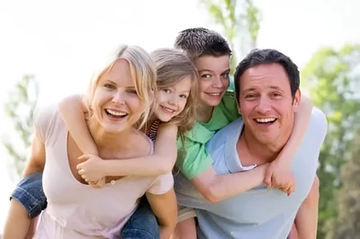 family laughing piled up outdoors