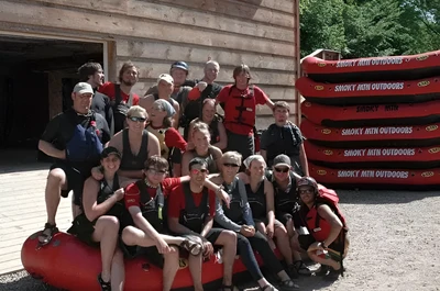 A group of friends posing for a photo before their rafting trip.