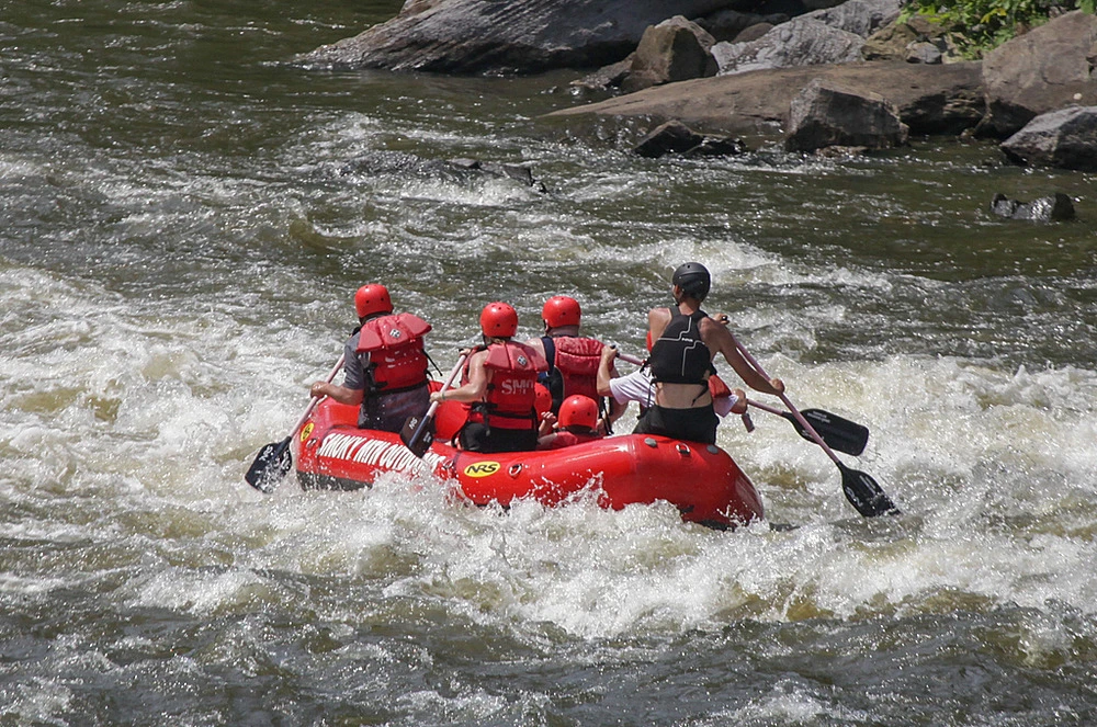 paddling raft through rapids on Pigeon River