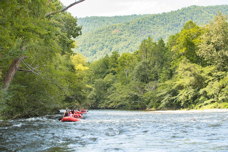 floating down Pigeon River surrounded by green mountains
