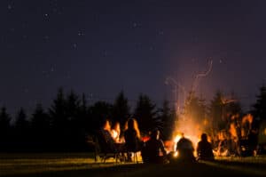 people sitting around campfire.