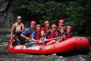 group rafting through shallow water