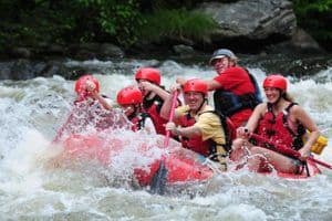 group laughing while white water rafting 