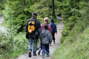 family hiking together through woods