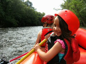 Little girl smiling while white water rafting
