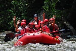 Smiling group of people white water rafting
