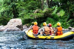 group in white water rafting down a river