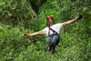 man enjoying ziplining through trees