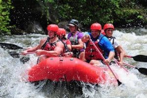 Enthusiastic group of friends going Pigeon River white water rafting.