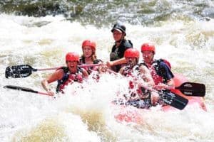 Group of friends having fun Pigeon River white water rafting.