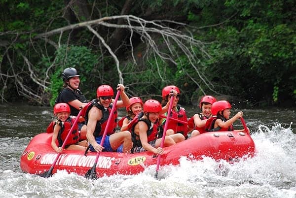 Happy family white water rafting on the Pigeon River.