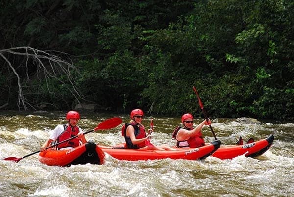 Three happy people having fun on a Smoky Mountain kayaking trip.