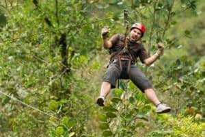 A man ziplining in the forest.