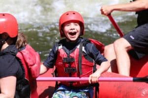 A boy smiling while river rafting in Gatlinburg TN.