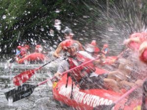 Rafters splashing in river