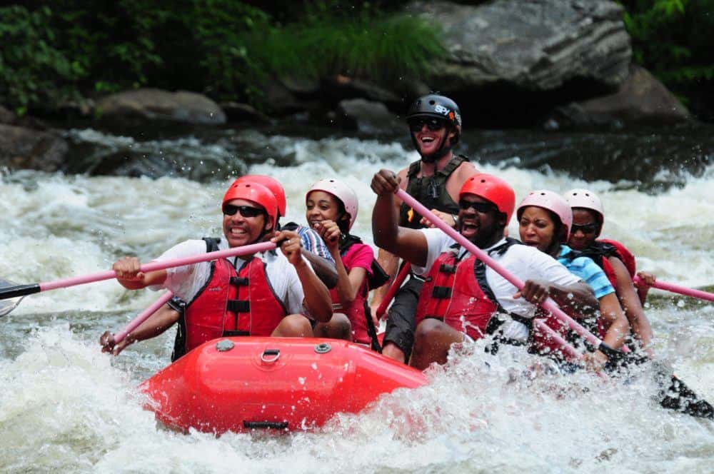 Laughing family enjoying a whitewater rafting trip with Smoky Mountain Outdoors