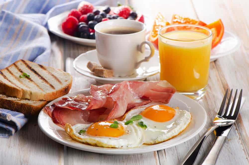 full breakfast with ham eggs, coffee, and orange juice