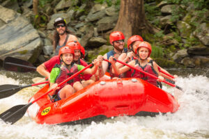 rafters wearing helmets and life jackets paddling through rapids