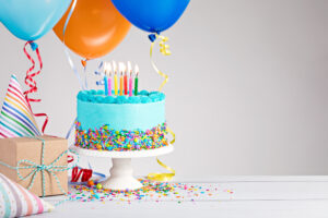 birthday cake, balloons, party hats, and wrapped gift