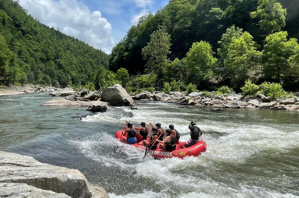 Smoky Mountain Outdoors raft navigating rapid on Pigeon River